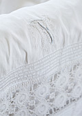 White fabric with lace edging and embroidered monogram