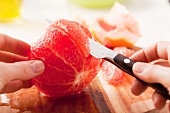 A grapefruit being filleted