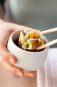 Won tons being dipped into soy sauce
