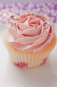Cupcake with strawberry icing and silver balls