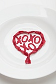 Weisser Teller mit Herzform aus roten Nudeln