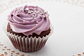 Chocolate cupcake with blackberry icing and silver balls