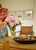 Wooden bowl and bouquet of roses in a glass jar