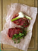 Raw beef steaks with garlic and herbs