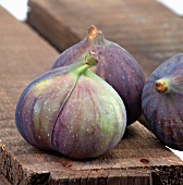 Three fresh figs on a wooden board