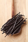 Bourbon and vanilla pods on an old wooden cooking spoon