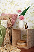 Wooden box with old books in front of floral wallpaper