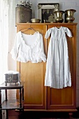 White women's clothing on hangers hanging in front of a clothes closet