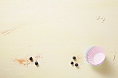Blueberries, brown sugar and cake cases on a wooden background