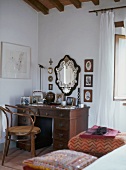 Antique desk with drawers and curved wood armchair in corner of bedroom