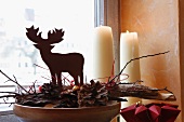 Weihnachtliche Hirschfigur auf Kiefernzapfen und Holz