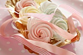 Pastel-coloured meringues with pink ribbons