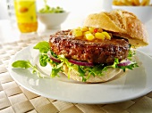 A homemade burger with lettuce, onions and corn
