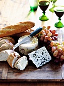 An arrangement with cheese, bread and grapes