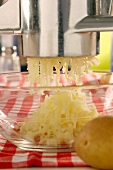 Pressing potatoes through a potato ricer
