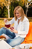 Woman pouring fruit tea at autumn picnic