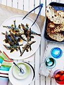 Grilled sardines and bread slices with chimichurri