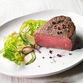 Medium rare pepper steak with a side salad