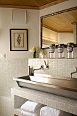 Antique accessories for a steel trough and white mosaic tiles in a modern bathroom