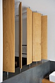 Drehbare Sichtschutzpaneele aus Holz auf einer Mauerbrüstung mit Schieferfliesen