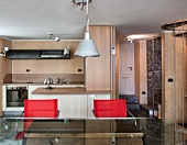 Offener Wohnraum in Berghütte mit rustikaler Natursteinwand und moderner Küche