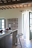 Kitchen counter with designer bar stool in front of open terrace door