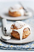 A profiterole with cream and icing sugar
