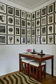 Bildersammlung mit schwarz weiß Zeichnungen über Biedermeier Tisch mit passenden Hockern in Zimmerecke