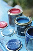 Three opened cans of paint