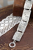 Armband aus verbundenen Silberplättchen mit geprägtem Blumenmuster