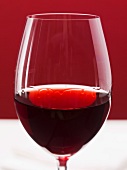 Ein Glas Rotwein mit 'Tränen' (Hinweis auf den Alkoholgehalt)