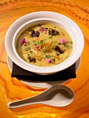 Bowl of Egg Drop Soup with Edible Flowers; Spoon
