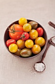 Verschiedene Tomaten und ein Löffel Salz