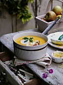 Pumpkin soup in a pot on a rustic table