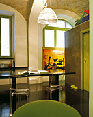 Simple Italian designer style - black multifunctional table with plexiglass chairs and cubic room-in-room installation placed in historic brick vault