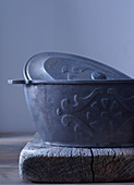 An iron, oval-shaped baking dish with a lid