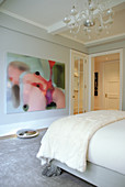 Französisches Bett mit postmodernen Klauenfüssen und moderne Kunst an der Wand in elegantem Schlafzimmer