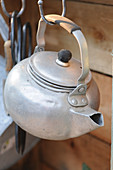 Old kettle hanging from hook
