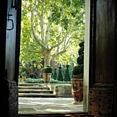 Blick vom Hauseingang in eine Gartenanlage mit Treppe und formgeschnittenen Büschen