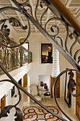 View of gallery and down into elegant foyer with patterned tiled floor through balustrade