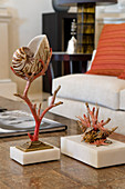 Decorative ornament made of coral and nautilus shell on table in front of pale sofa