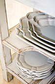 Tellerstapel und Servierplatten im traditionellen Landhausstil in weißem Vintage Regal