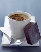 Kaffeegetränk und ein Stück Schokolade