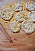Pizza Doughs on a Wooden Surface with Corn Meal and a Rolling Pin