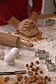 A child kneading biscuit dough on a floured work surface