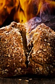Steaming whole meal bread, broken in half, in front of a fire