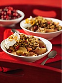 Pear and cranberry crumble with pecan nuts and cream