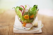 A mixed leaf salad with radishes and cherry tomatoes
