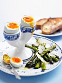 Soft boiled eggs and green asparagus with Parmesan cheese
