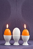 Easter egg and egg-shaped candles in egg cups